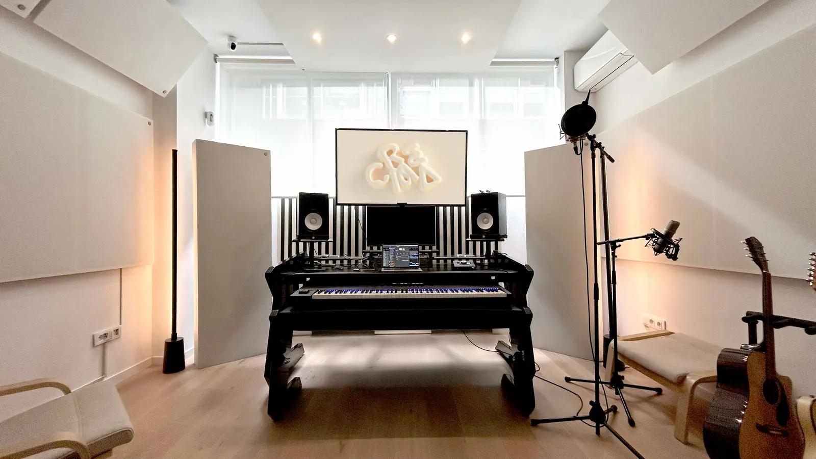 Sala principal de CREMA Studio con mesa de producción, teclado, monitores Yamaha y guitarras